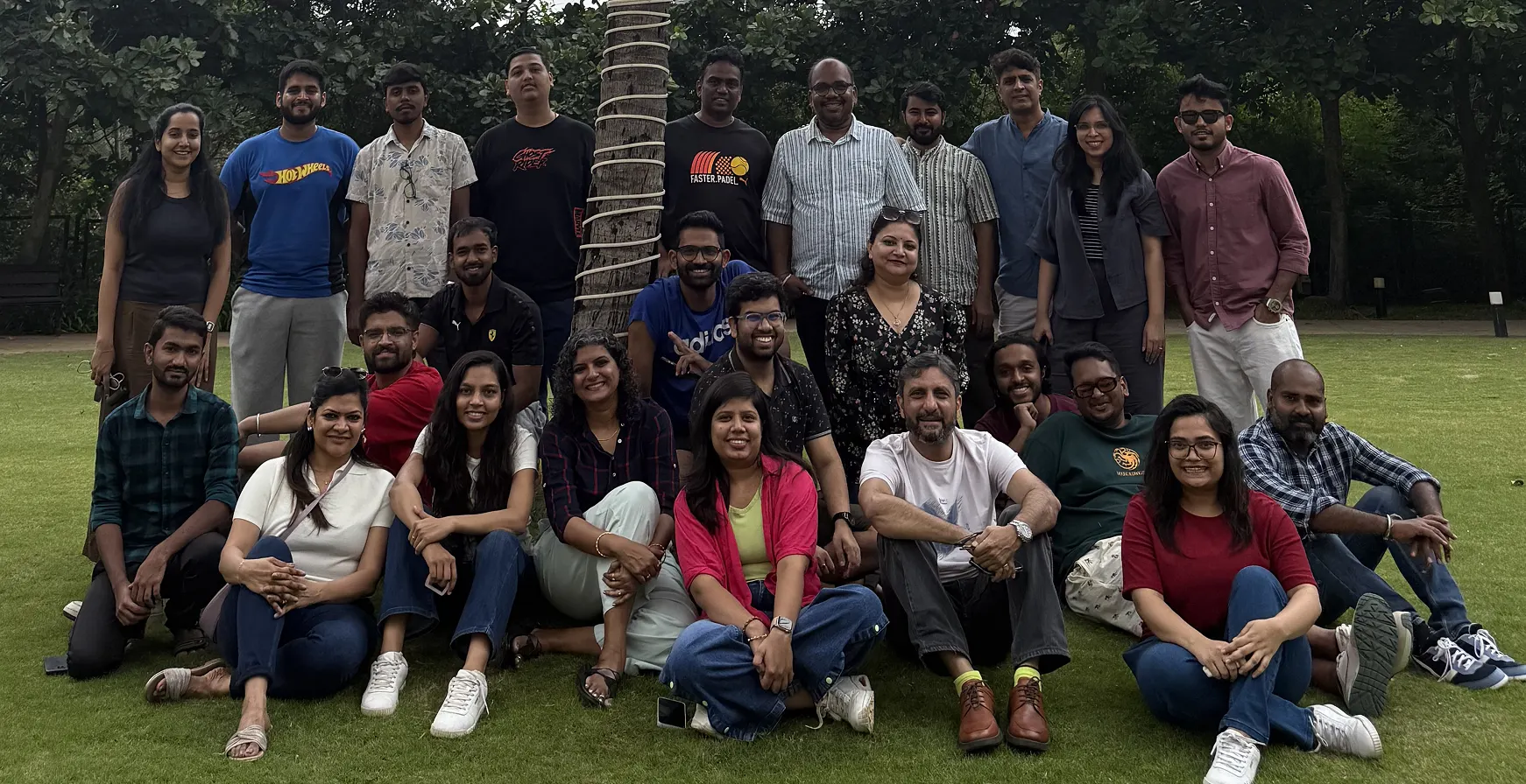 The Artium team sitting together on a lawn at the team offsite